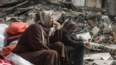 Palästinenserinnen sitzen auf Trümmern im Flüchtlingslager Nuseirat im Gazastreifen nach dem Abzug der israelischen Streitkräfte (IDF). (Foto: Omar Naaman/dpa)