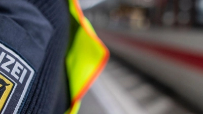 Ein Bundespolizist steht am Hauptbahnhof vor einem ICE. Nachdem ihm die Weiterfahrt untersagt wurde, hat ein schottischer Fußballfan einen Zugbegleiter in Unterfranken beleidigt und angegriffen. (Foto: Patrick Seeger/dpa)