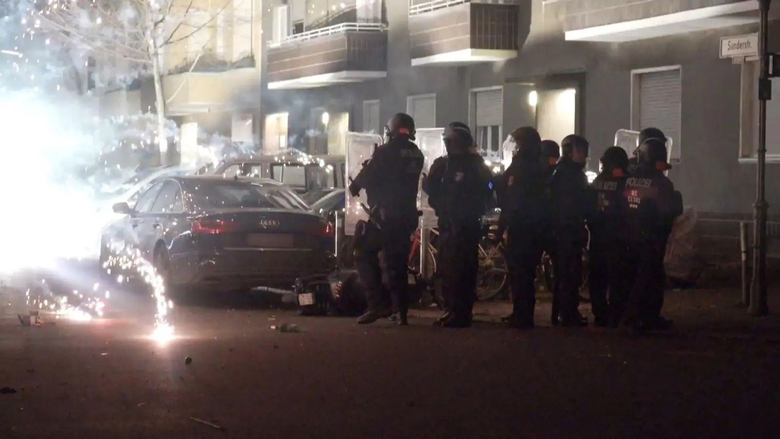 Polizisten stehen in der Silvesternacht 2022 hinter explodierendem Feuerwerk in Berlin. (Foto: Julius-Christian Schreiner/TNN/dpa)