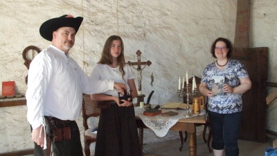 Deborah Wüstner (rechts) stellte ihr Buch „Die Hexe und der Henker“ im „Drudengewölbe“ im Rothenburger Torturm vor. Dort fand im Zuge der Hexenverfolgung in Dinkelsbühl die „peinliche Befragung“ statt. Dabei kamen unter anderem Daumenschrauben zum Einsatz, die Bernd Lindörfer vom Vorstand der „Dinkelsbühler Reichsstädter – Freunde historischer Spiele“ seiner Tochter Lena für das Foto anlegte – ohne diese anzuziehen. (Foto: Jasmin Kiendl)