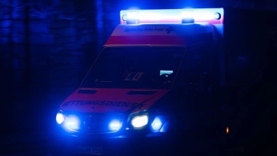 Ein Krankenwagen fährt mit Blaulicht durch eine Straße in der Nacht. (Foto: Nicolas Armer/dpa/Symbolbild)