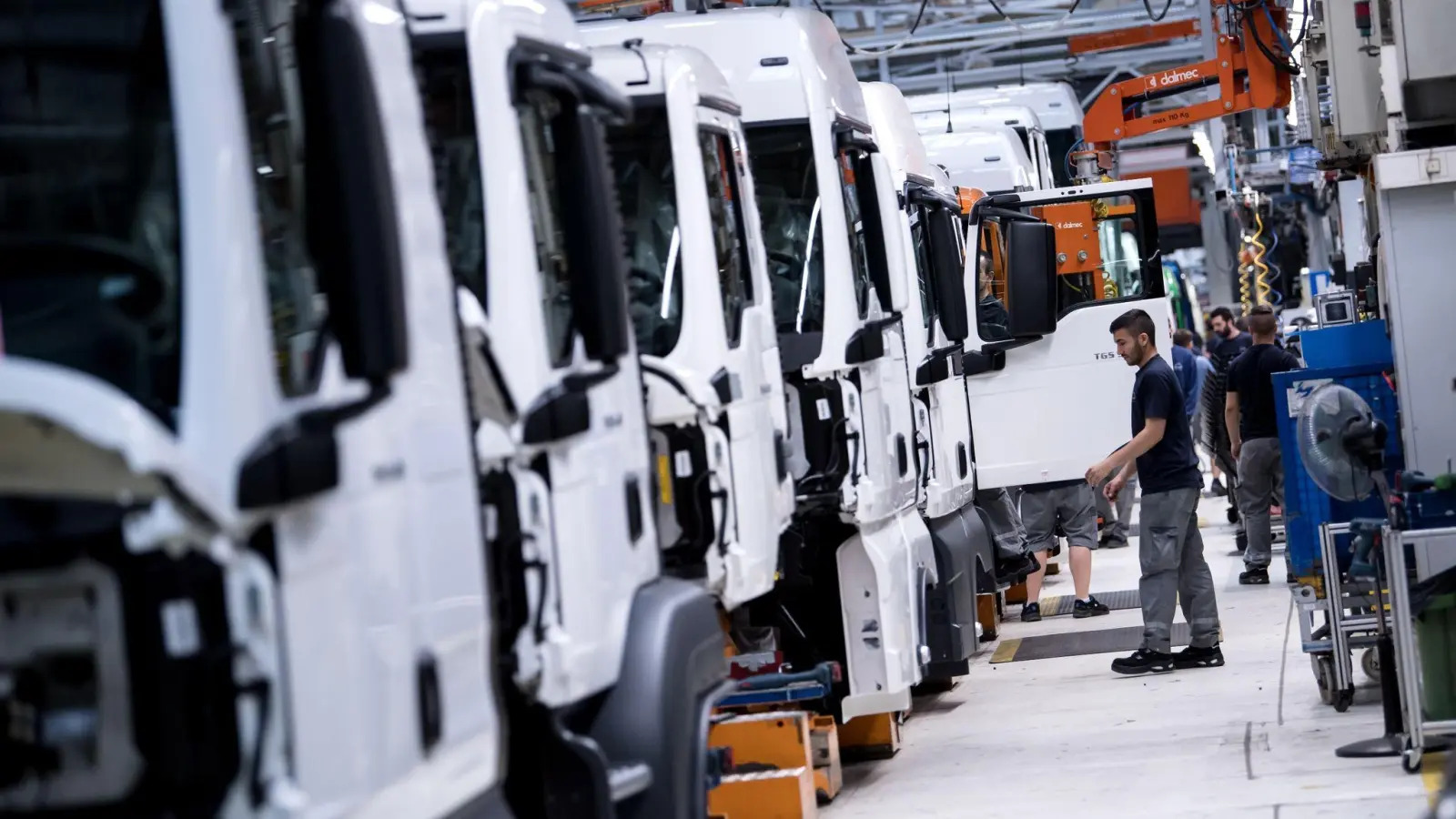 Mitarbeiter von MAN Truck &amp; Bus arbeiten an einer Produktionsstraße an einem LKW. (Foto: Sven Hoppe/dpa/Archivbild)