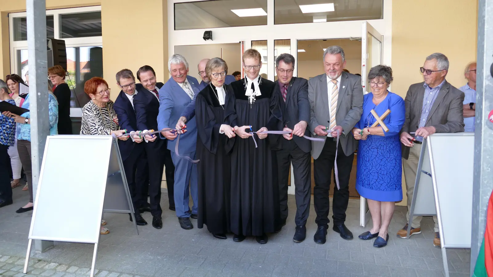 Endlich war es so weit: Nach den Ansprachen wird das Band vor dem neuen Haus der Kirche an der Ringstraße 25 in Uffenheim feierlich durchschnitten. (Foto: Sylvia Fehlinger)