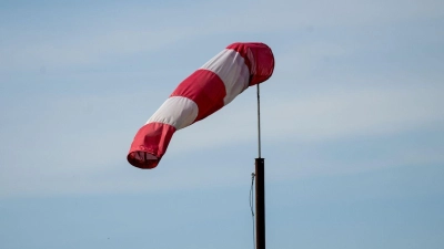 Eine Windfahne weht in der Luft. (Foto: Pia Bayer/dpa/Symbolbild)