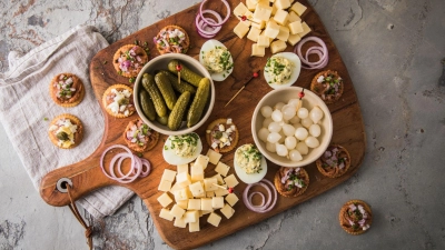 Eine typische niederländische Borrel-Platte mit Filet Americain auf Crackern mit Zwiebel, Ei oder Kapern. Dazu werden Käsewürfel, Cornichons, Silberzwiebeln und gefüllte Eier mit Schnittlauch serviert. (Foto: Christin Klose/dpa-tmn)