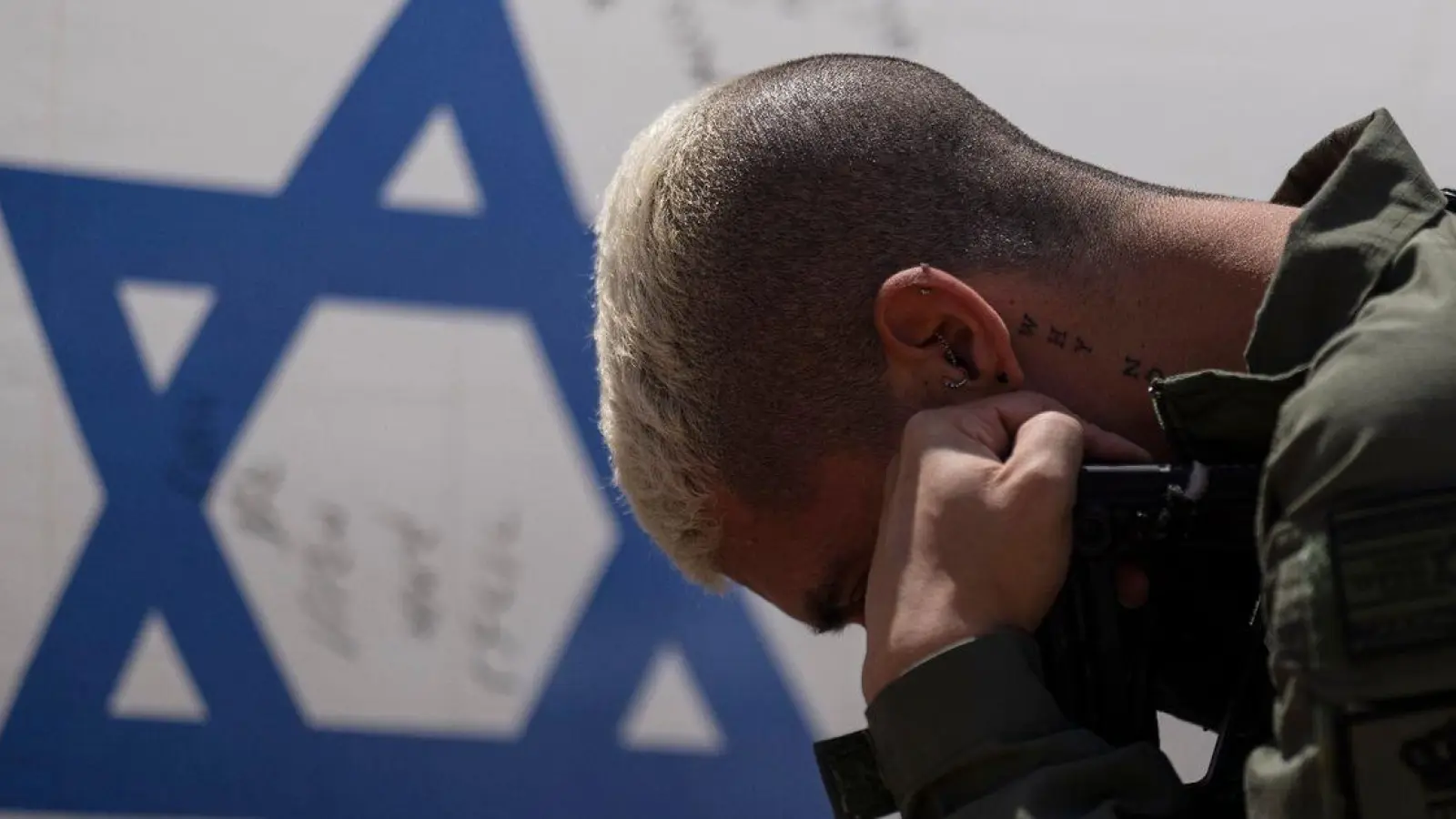 Ein israelischer Soldat neben der Nationalflagge: Gibt es für Israel einen Ausweg aus dem Schlamassel? (Foto: Leo Correa/AP/dpa)