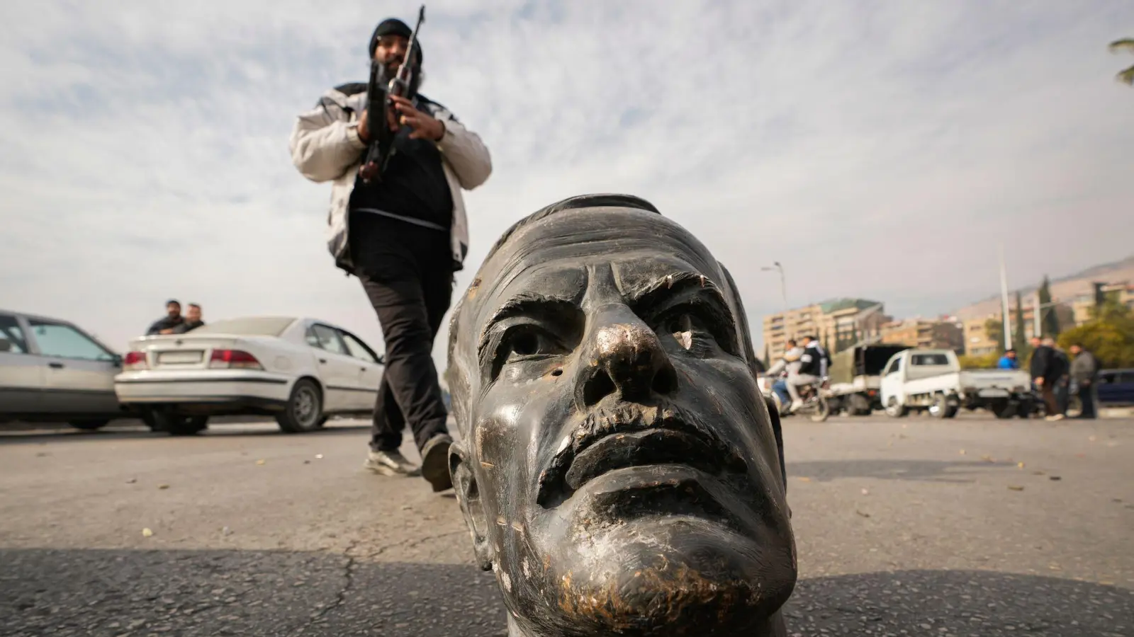 Ein abgetrennter Kopf einer Statue des verstorbenen syrischen Präsidenten Hafis al-Assad liegt in Damaskus auf der Straße. Eine Allianz aus Aufständischen hat in Syrien die Macht übernommen. (Foto: Hussein Malla/AP/dpa)