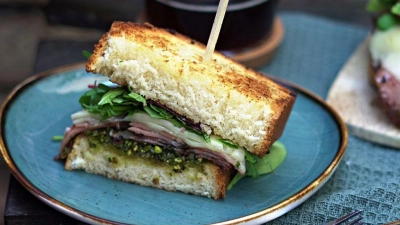 Eine Frühstücksidee für einen sonnigen Sonntagmorgen: Mareike Puckas Frühstücksburger mit gegrillter Mortadella und Basilikum-Pistazien-Pesto. (Foto: Mareike Pucka/biskuitwerkstatt.de/dpa)