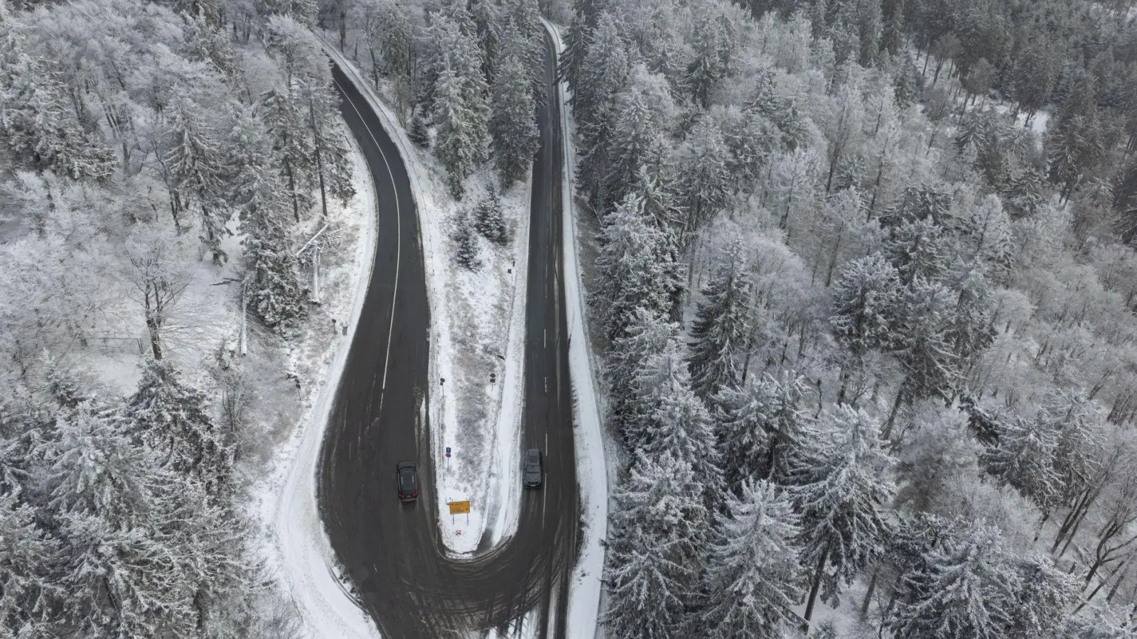 Eine Luftaufnahme mit einer Drohne zeigt Schnee auf den Bäumen des Feldberg im Taunus. (Foto: Boris Roessler/dpa)