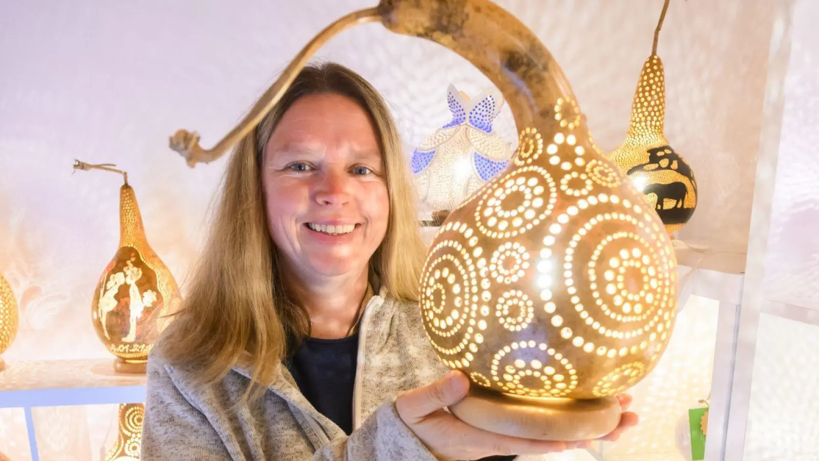 Virginia Lauterbach präsentiert eine ihrer handgefertigten Kürbislampen in der Kalebassenmanufaktur in Bückeburg. (Foto: Julian Stratenschulte/dpa)