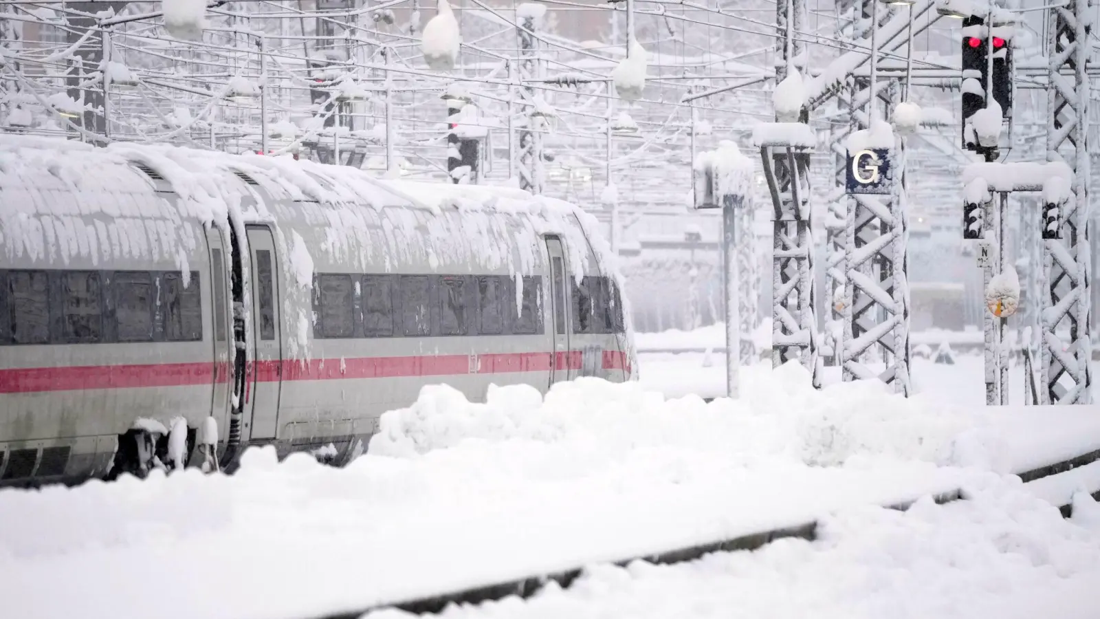 Ein ICE steht nach starkem Schneefall am Hauptbahnhof in München. (Foto: Matthias Schrader/AP/dpa)