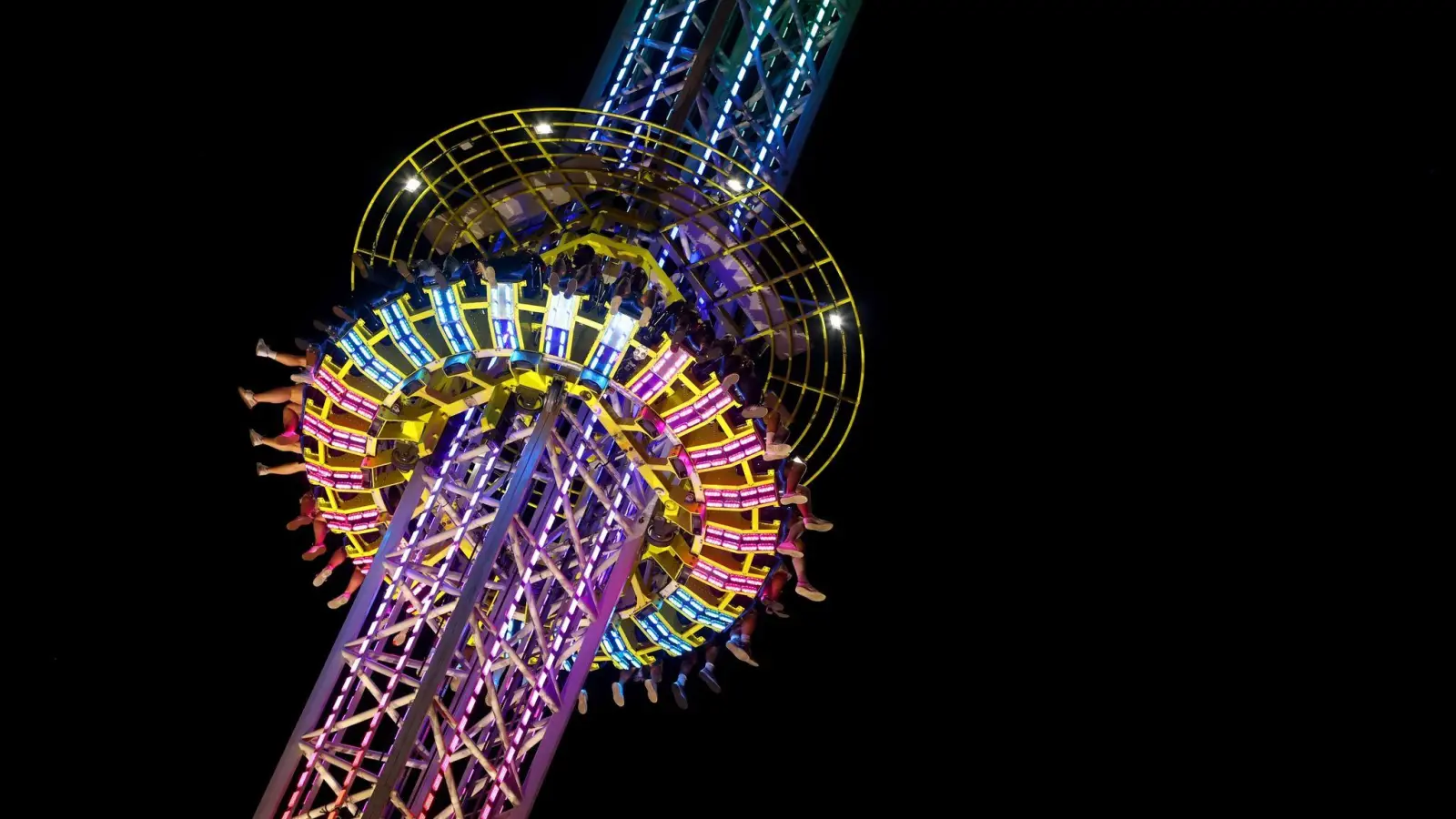 Die Beine von Oktoberfestbesuchern sind am abendlichen Himmel in einem Fahrgeschäft zu sehen. (Foto: Karl-Josef Hildenbrand/dpa)