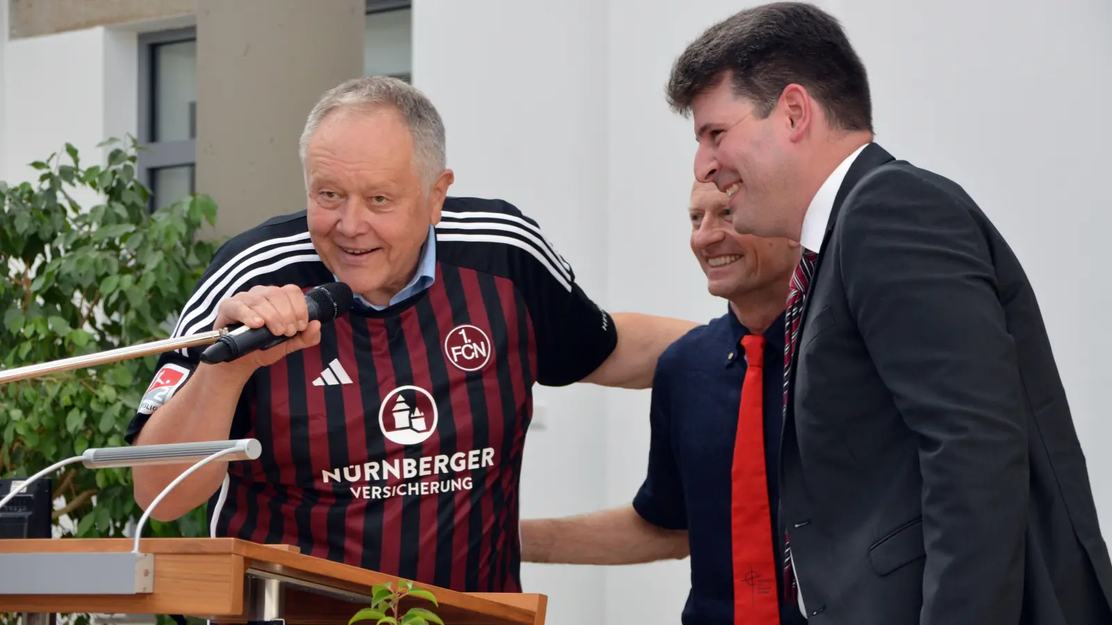 Alfred „Don Alfredo“ Lockl (links) im Glubb-Trikot mit Teilen seines „Inner Circles“ – Realleiter Ralf Lischka (Mitte) und der Geschäftsführer der CvB-Stiftung, Christoph Kilian. (Foto: Johannes Zimmermann)