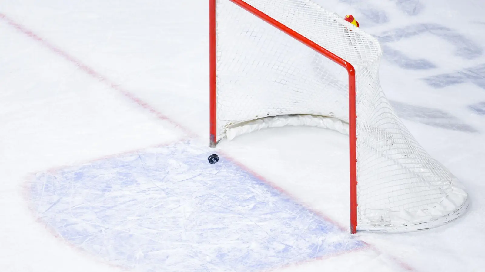 Ein Puck fliegt in ein leeres Eishockey-Tor. (Foto: Uwe Anspach/Deutsche Presse-Agentur GmbH/dpa/Symbolbild)