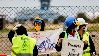 Als Pinguine verkleidete Aktivistin versuchen den Flughafen auf Sylt zu blockieren. (Foto: Axel Heimken/dpa)