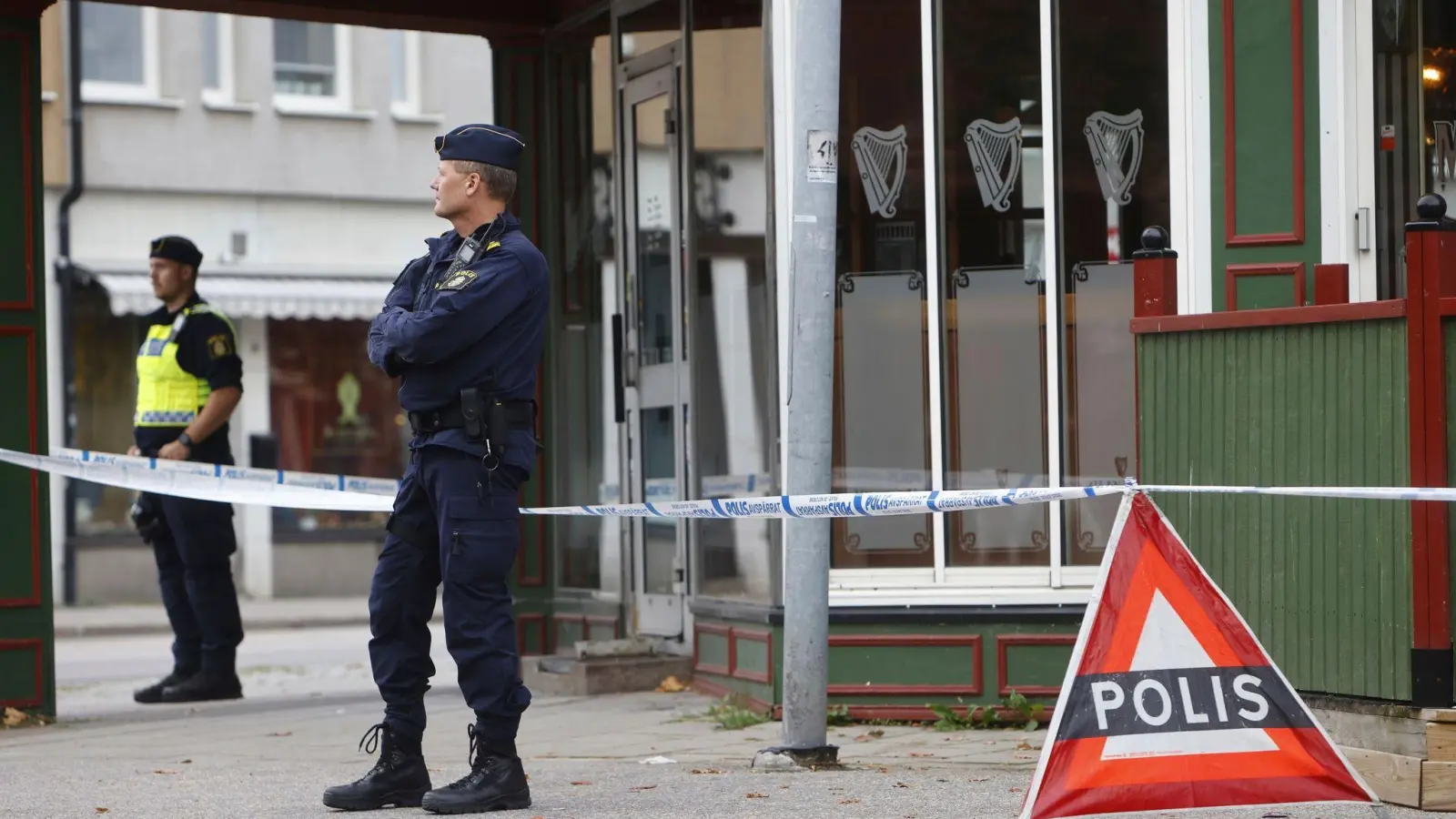 Polizisten stehen vor der Kneipe in Sandviken, in der zwei Menschen starben und zwei weitere verletzt wurden. (Foto: Henrik Hansson/TT News Agency/AP/dpa)