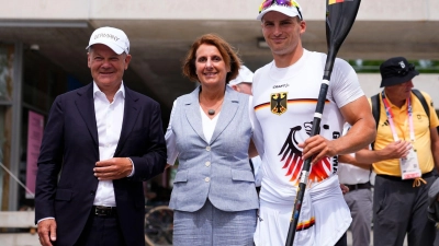 Bundeskanzler Olaf Scholz (l) und seine Frau Britta Ernst lassen sich mit Olympiasieger Tom Liebscher-Lucz fotografieren. (Foto: Lindsey Wasson/AP/dpa)