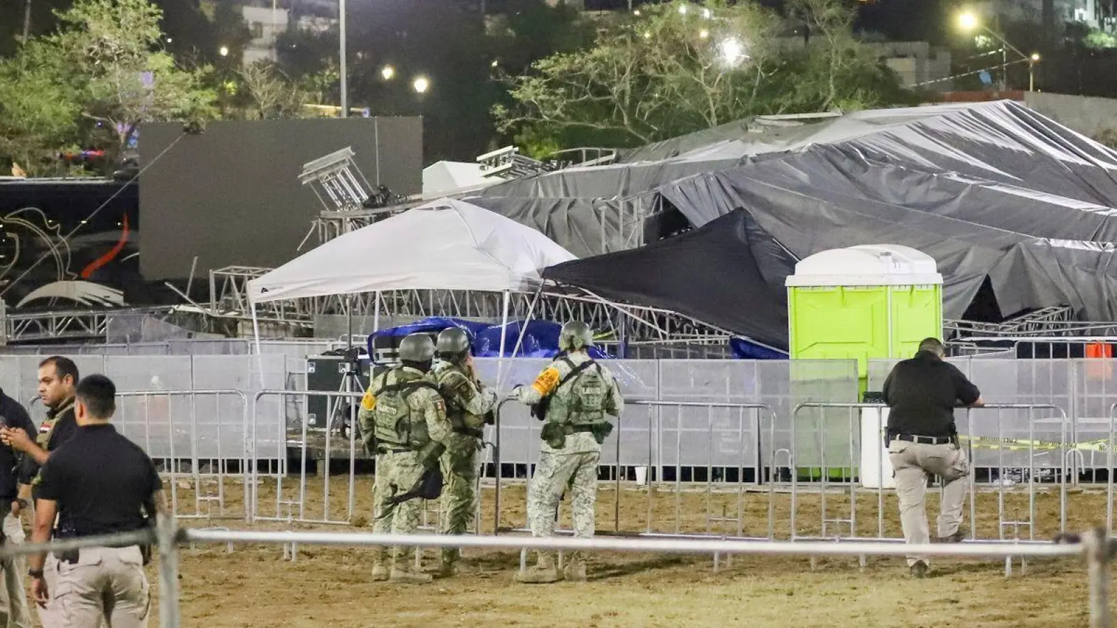 Sicherheitskräfte stehen um die Bühne, die zusammengebrochen ist. (Foto: Alberto Lopez/AP/dpa)