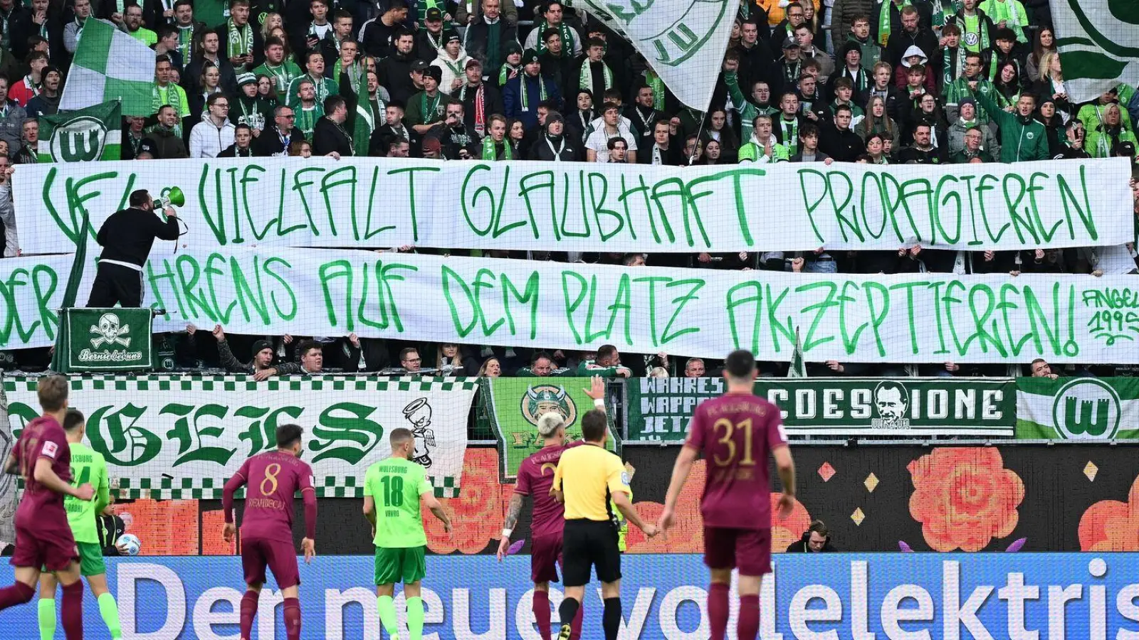 Wolfsburgs Fans mit einem Banner mit der Aufschrift „VfL Vielfalt glaubhaft propagieren - oder Behrens auf dem Platz akzeptieren“. (Foto: Swen Pförtner/dpa)