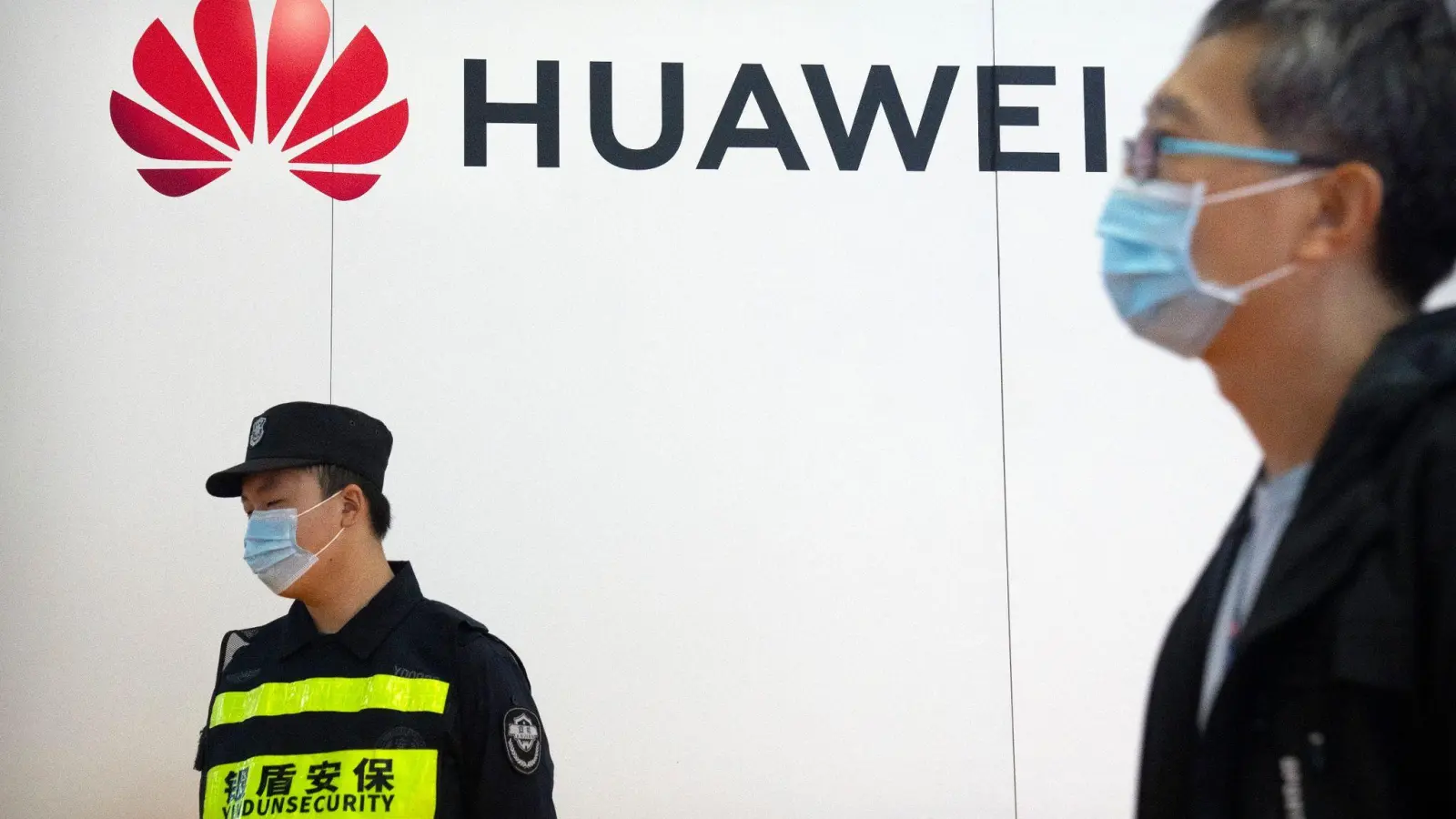 Ein Wachmann steht auf der PT Expo in Peking an einem Stand des chinesischen Technologieunternehmens Huawei. (Foto: Mark Schiefelbein/AP/dpa)