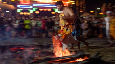 Fest der neun Kaisergötter in Malaysia: Ein Mann geht barfuß über brennendes Holz und glühende Kohlen. (Foto: Vincent Thian/AP)