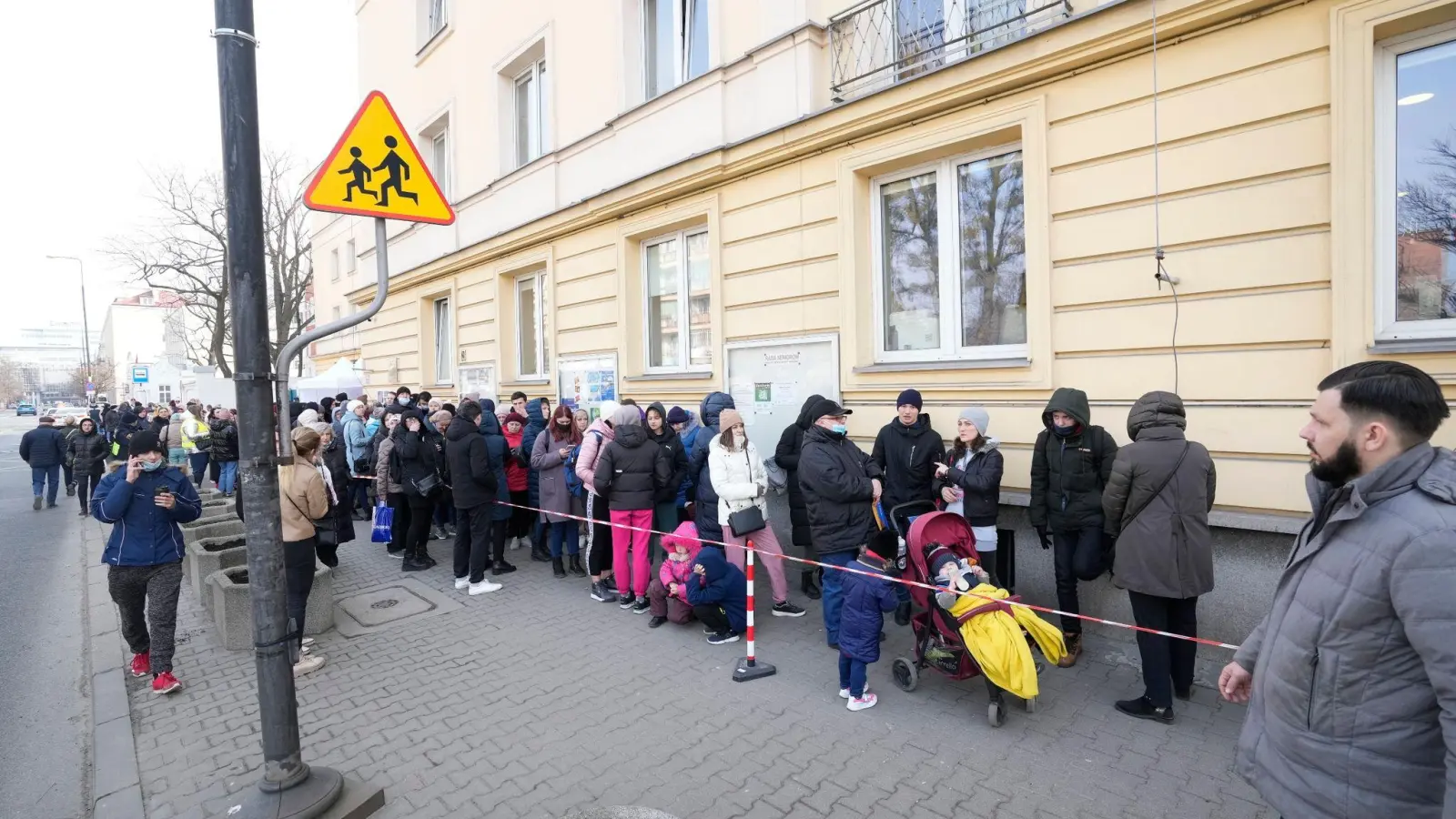 Aus der Ukraine geflüchtete Menschen stehen vor einer Meldestelle Schlange. (Foto: Czarek Sokolowski/AP/dpa)