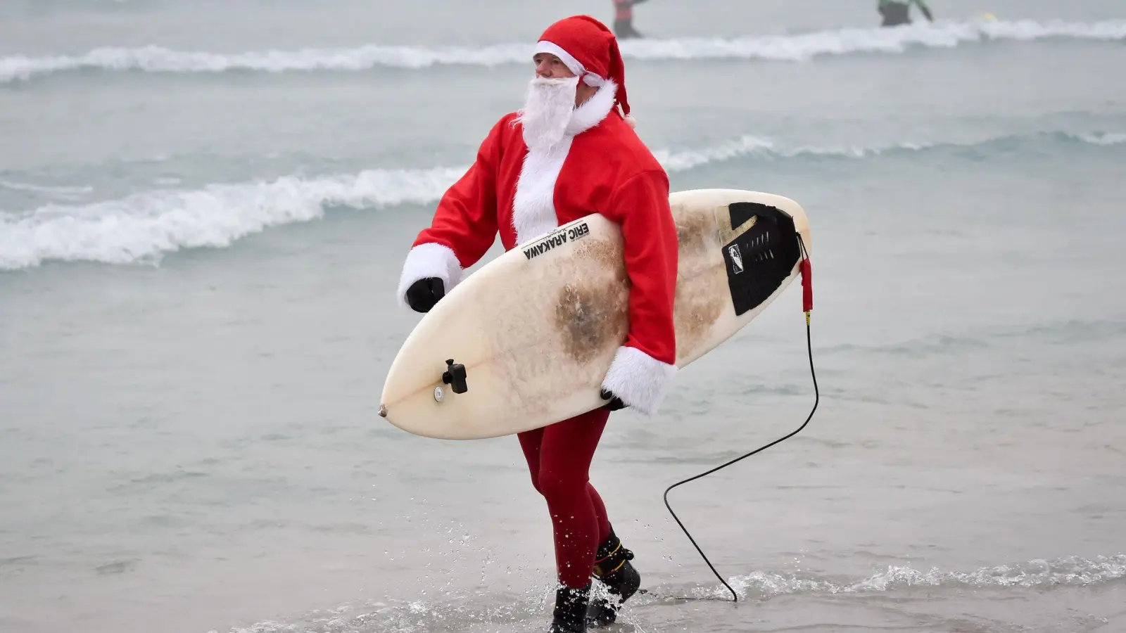 Events mit surfenden Weihnachtsmännern gibt es mittlerweile in mehreren Ländern. (Archivbild) (Foto: Ben Birchall/PA Wire/dpa)