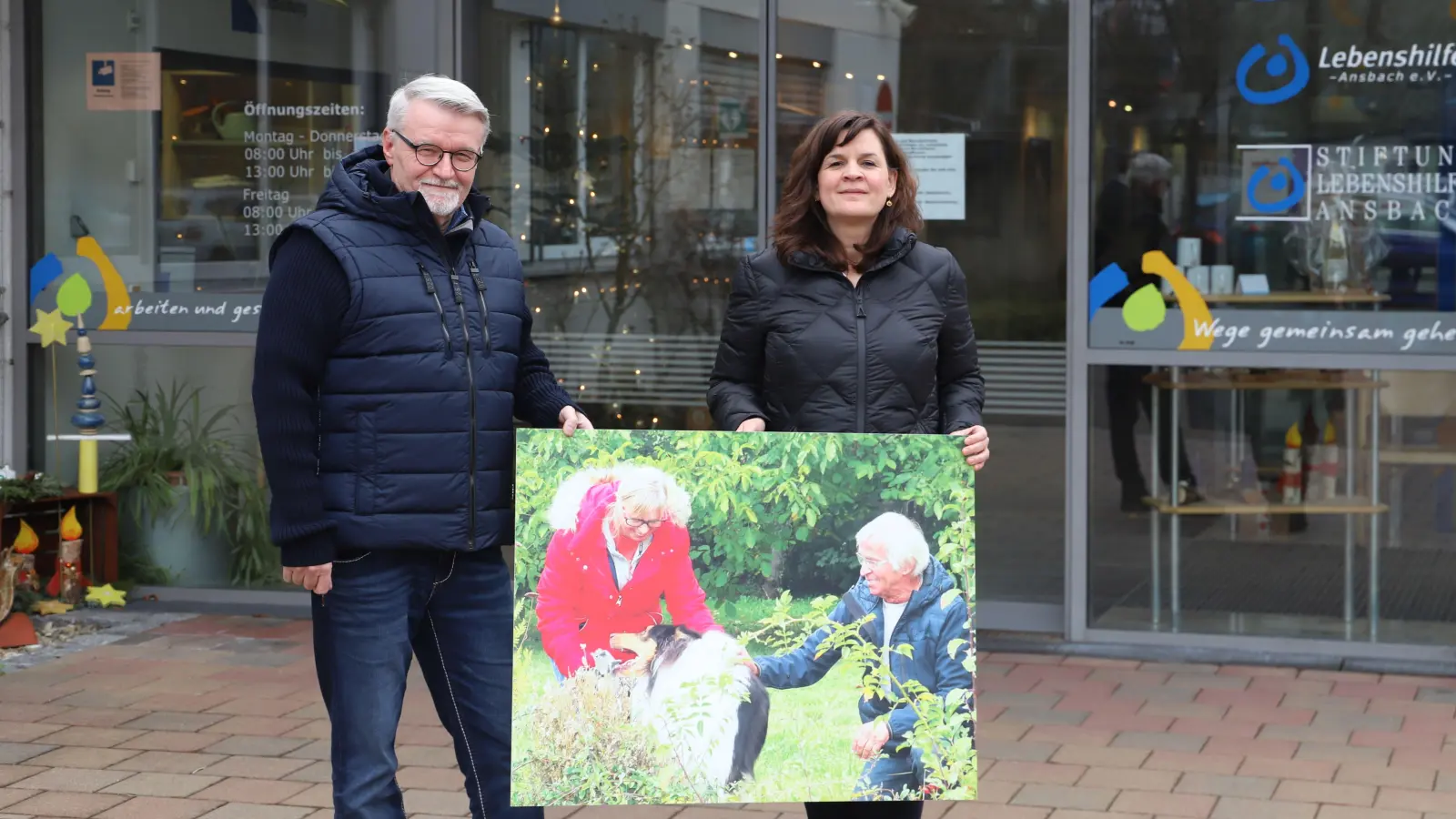 Eine Ausstellung widmet sich dem Jubiläum: Die Lebenshilfe-Vertreter Nathalie Lober und Harald Eisner zeigen eines der Bilder, die im September im Brücken-Center zu besichtigen sein sollen. (Foto: Oliver Herbst)