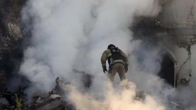 Ein Feuerwehrmann geht durch den Qualm eines brennenden Hauses in Charkiw. (Foto: -/https://photonew.ukrinform.com/ Ukrinform/dpa)
