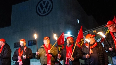 Mitarbeiter von Volkswagen stehen mit Fackeln vor dem VW Werk in Osnabrück. Die IG Metall hat ihre Mitglieder in der Metall- und Elektroindustrie zu flächendeckenden Warnstreiks aufgerufen. (Foto: Guido Kirchner/dpa)