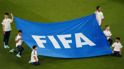 Kinder halten ein Banner mit der Aufschrift „FIFA”. (Foto: Mike Egerton/Press Association/dpa)