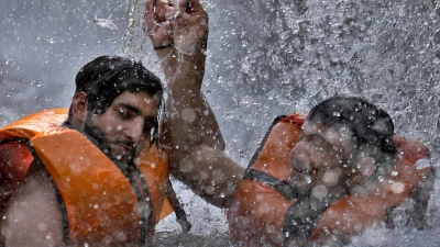 Zwei pakistanische Männer kühlen sich in Islamabad in einem Bach ab. (Foto: Anjum Naveed/AP/dpa)