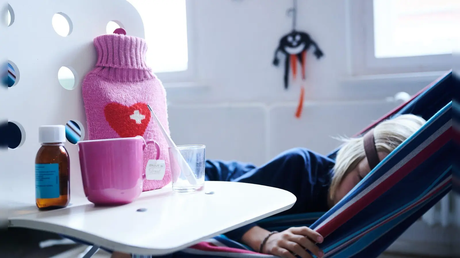 Fieberthermometer, Hustensaft, Wärmflasche und eine Tasse Tee: Die Wellen von Atemwegsinfektionen in Deutschland flachen langsam ab. (Foto: Annette Riedl/dpa)