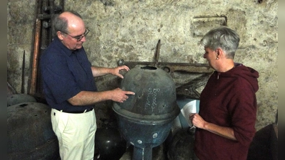 Susanne Frieß und Stadtführer Alexander Biernoth betrachten die Turmkugel, die einst die Brodswindener Kirche zierte. (Foto: Winfried Vennemann)