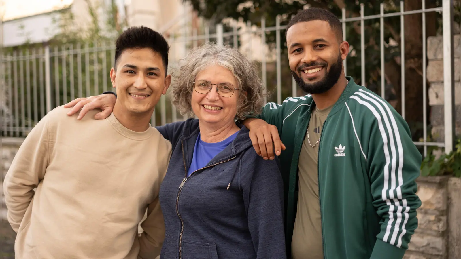 Hosein Rezaie (links) neben seiner Pflegemutter Monika Gaubitz und sein Freund Michael Grmay-Gbremichael. Zehn Jahre leben die beiden jungen Männer im Landkreis Neustadt/Aisch-Bad Windsheim, der ihnen zur Heimat geworden ist. (Foto: Andreas Riedel)