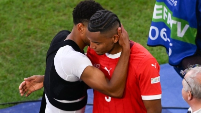 Englands Jude Bellingham (l) tröstet nach dem Spiel den traurigen Schweizer Manuel Akanji. (Foto: David Inderlied/dpa)