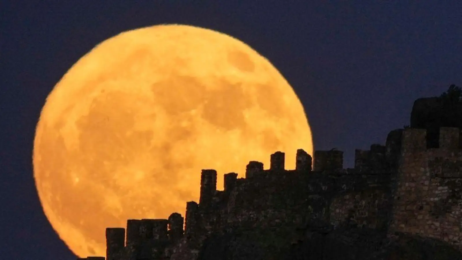 Groß und gelb: Der Vollmond geht hinter der alten Burg Karahisar in Afyonkarahisar in der Zentraltürkei auf. (Foto: Emrah Gurel/AP/dpa)