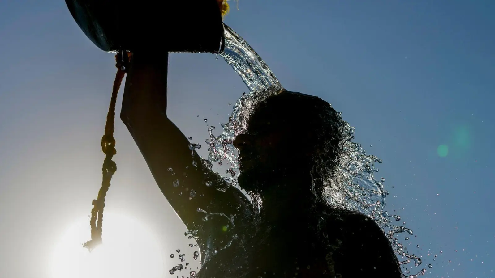 Hitze im Libanon: Ein Mann gießt sich kaltes Wasser über den Kopf, nachdem er Beachvolleyball gespielt hat. (Foto: Hassan Ammar/AP/dpa)