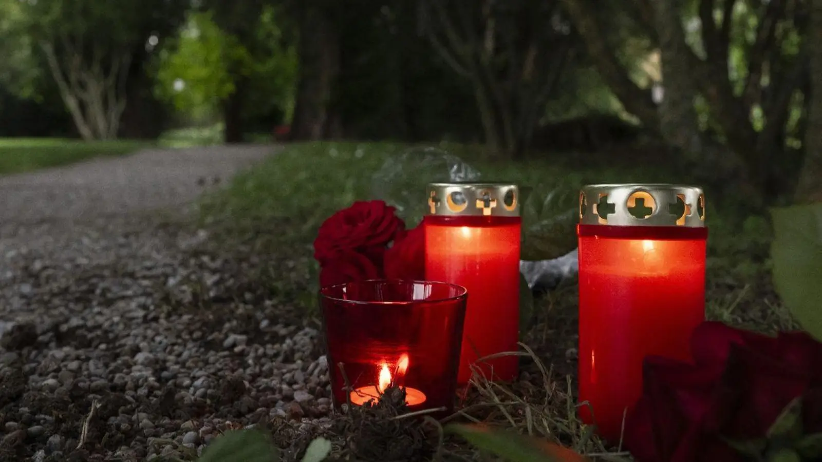 Blumem und Kerzen liegen im Park an dem Tatort im schweizerischen Männedorf. (Foto: Ennio Leanza/KEYSTONE/dpa)