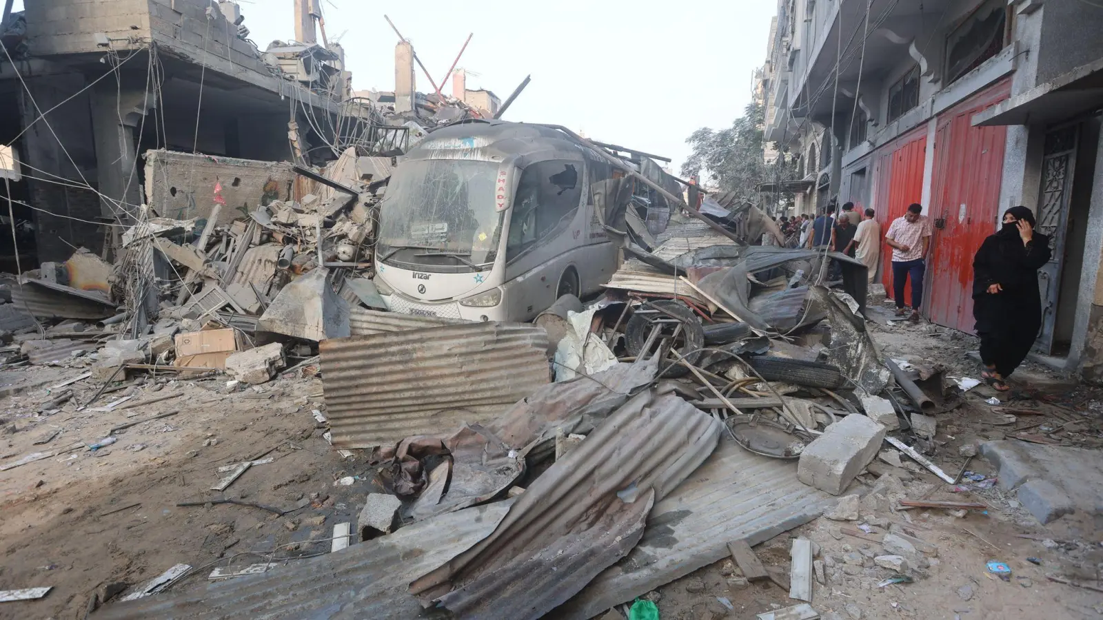 Eine palästinensische Frau geht durch die Trümmer eines Gebäudes, das bei einem israelischen Luftangriff im Gazastreifen getroffen wurde. (Foto: Ahmed Zakot/SOPA Images via ZUMA Press Wire/dpa)