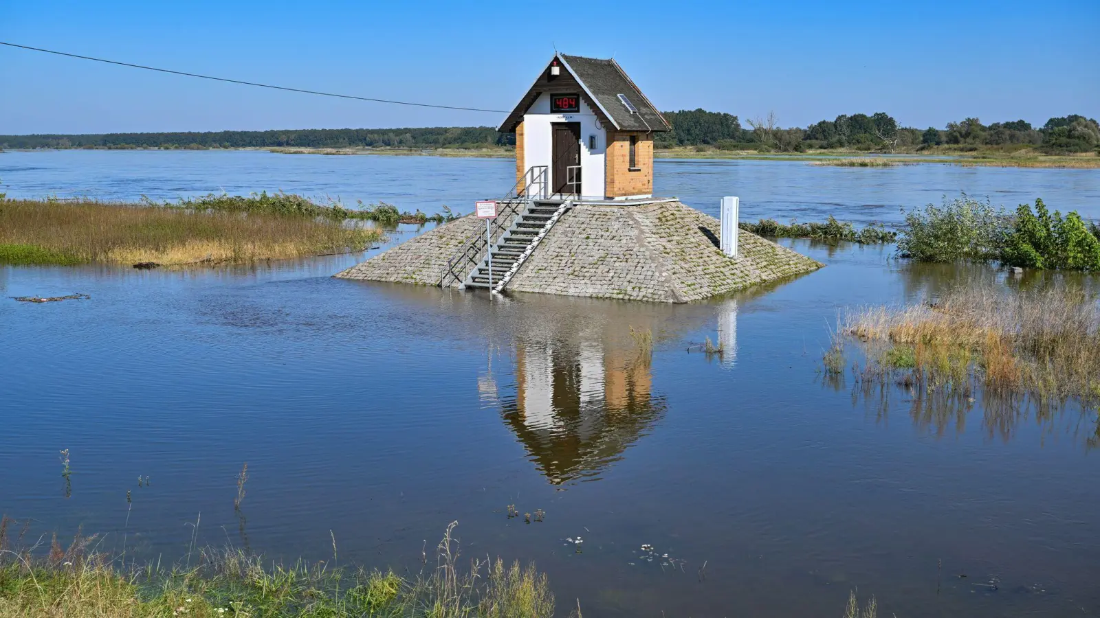 Rund um das Pegelhäuschen auf einem Sockel am Oderufer in Ratzdorf (Oder-Spree-Kreis) ist schon der hohe Wasserstand zu sehen. (Foto: Patrick Pleul/dpa)