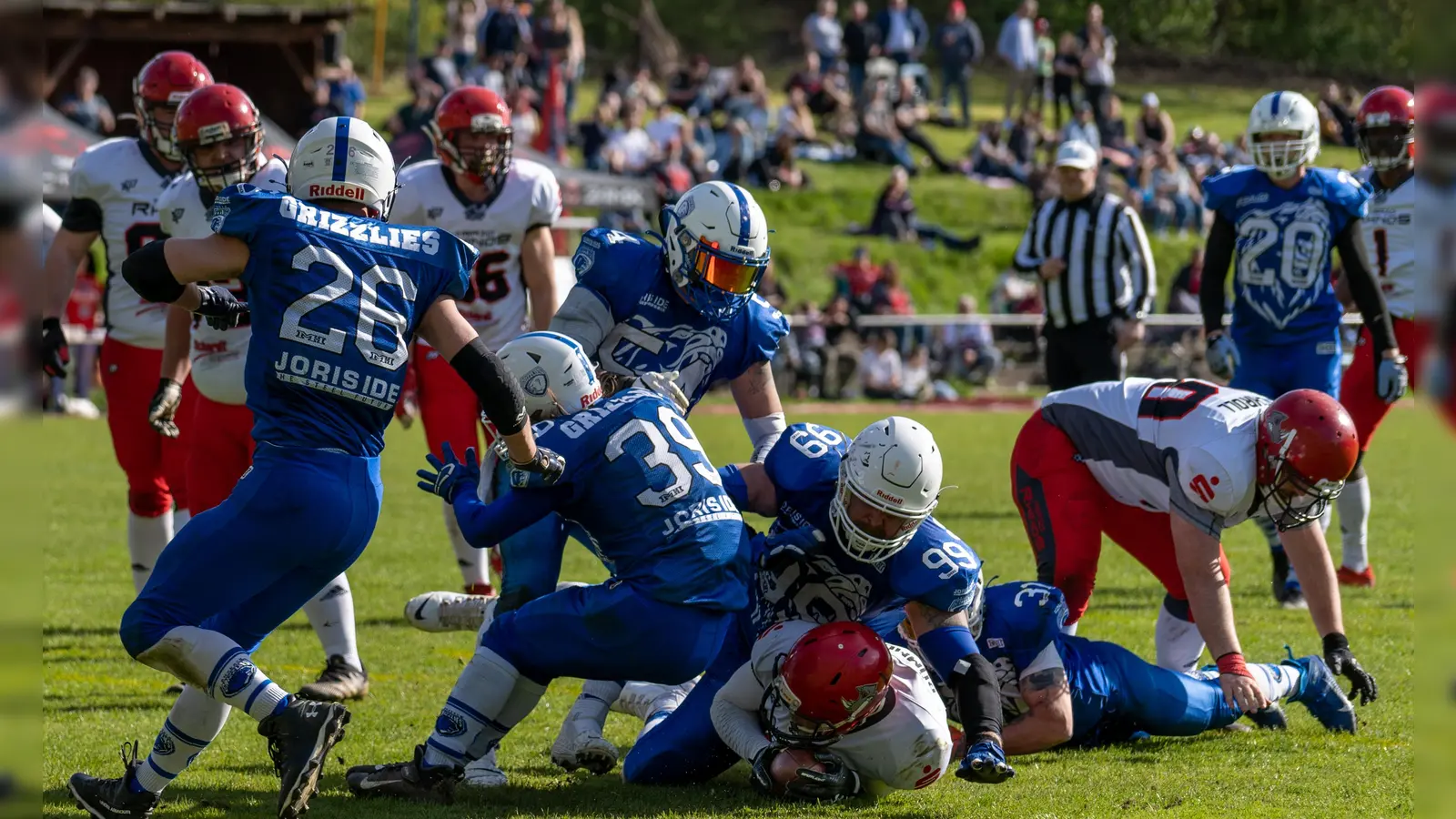 Der starke Ansbacher „Nose-Tackle“ Christopher Auspelmyer (Bildmitte, mit der Nummer 99) bei einem Tackle gegen den Herzogenauracher Ballträger (ganz unten). (Foto: Tobias Wernick)