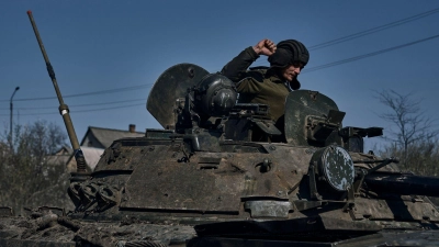 Ein ukrainischer Soldat gestikuliert auf einem gepanzerten Mannschaftstransportwagen an der Frontlinie in Bachmut. (Foto: LIBKOS/AP/dpa)