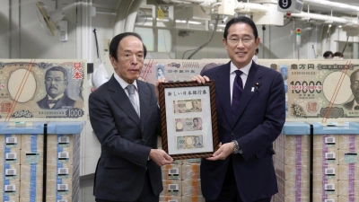 Japans Premierminister Fumio Kishida (r) und der Gouverneur der Bank of Japan, Kazuo Ueda, präsentieren die neuen Banknoten in Tokio. (Foto: Uncredited/Japan Pool via Kyodo News/dpa)