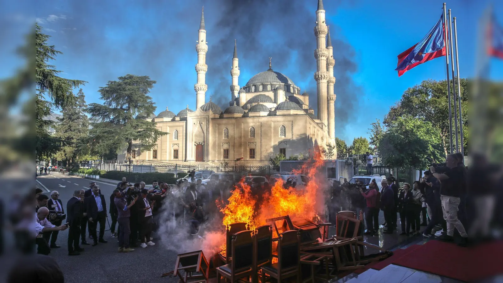 Mitglieder der oppositionellen Demokratischen Partei Albaniens verbrennen Stühle am Eingang des Parlaments mit den Worten, dass ihre Stühle den Bürgern gehören. (Foto: Armando Babani/ZUMA Press Wire/dpa)