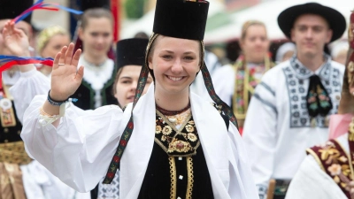 In traditioneller Tracht laufen Teilnehmer eines Trachtenumzuges der Siebenbürger Sachsen durch die Altstadt von Greding. (Foto: Timm Schamberger/dpa)