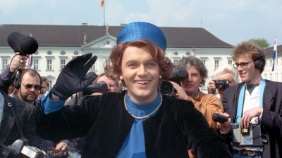 Verkleidet als Königin Beatrix winkt der deutsche Komiker und Showmaster Hape Kerkeling vor Schloss Bellevue für die Presse. (Archivfoto von 1991) (Foto: picture alliance / dpa)