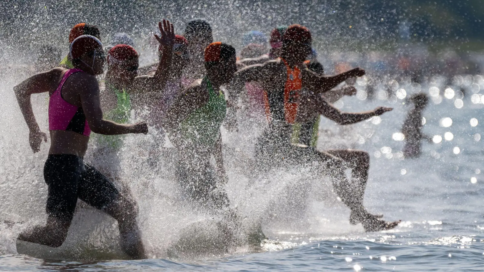 Rettungsschwimmer laufen ins Wasser: Rund 190 Rettungsschwimmer aus fünf Ländern nehmen an dem Finale in der Disziplin „Oceanman” in Warnemünde teil.  (Foto: Stefan Sauer/dpa)