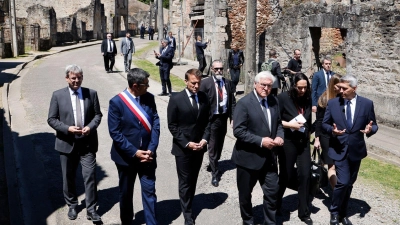Der französische Präsident Emmanuel Macron und der deutsche Bundespräsident Frank-Walter Steinmeier gehen an Ruinen in Oradour-sur-Glane vorbei. (Foto: Ludovic Marin/AFP Pool/AP/dpa)