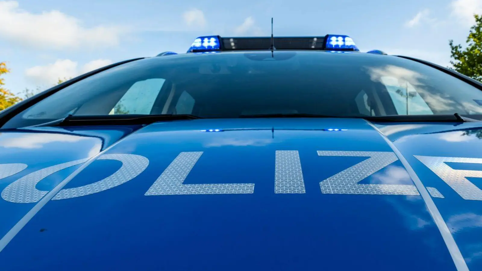 Auf der Motorhaube eines Streifenwagens steht der Schriftzug „Polizei“. (Foto: David Inderlied/dpa/Illustration)